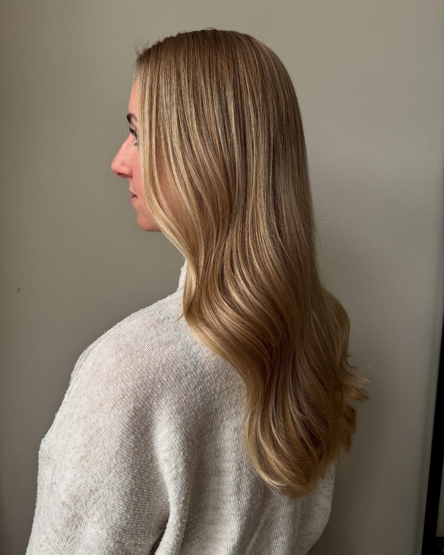 Lang honingblond haar met zachte slagen, van opzij