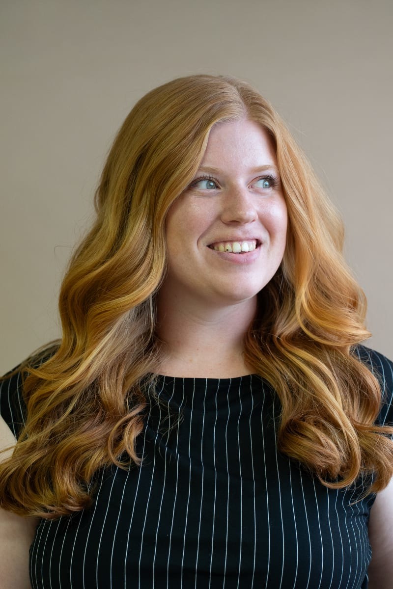 Glimlachende vrouw met lang koperkleurig haar, profielfoto van Hairfashion by Sabine op Salonized